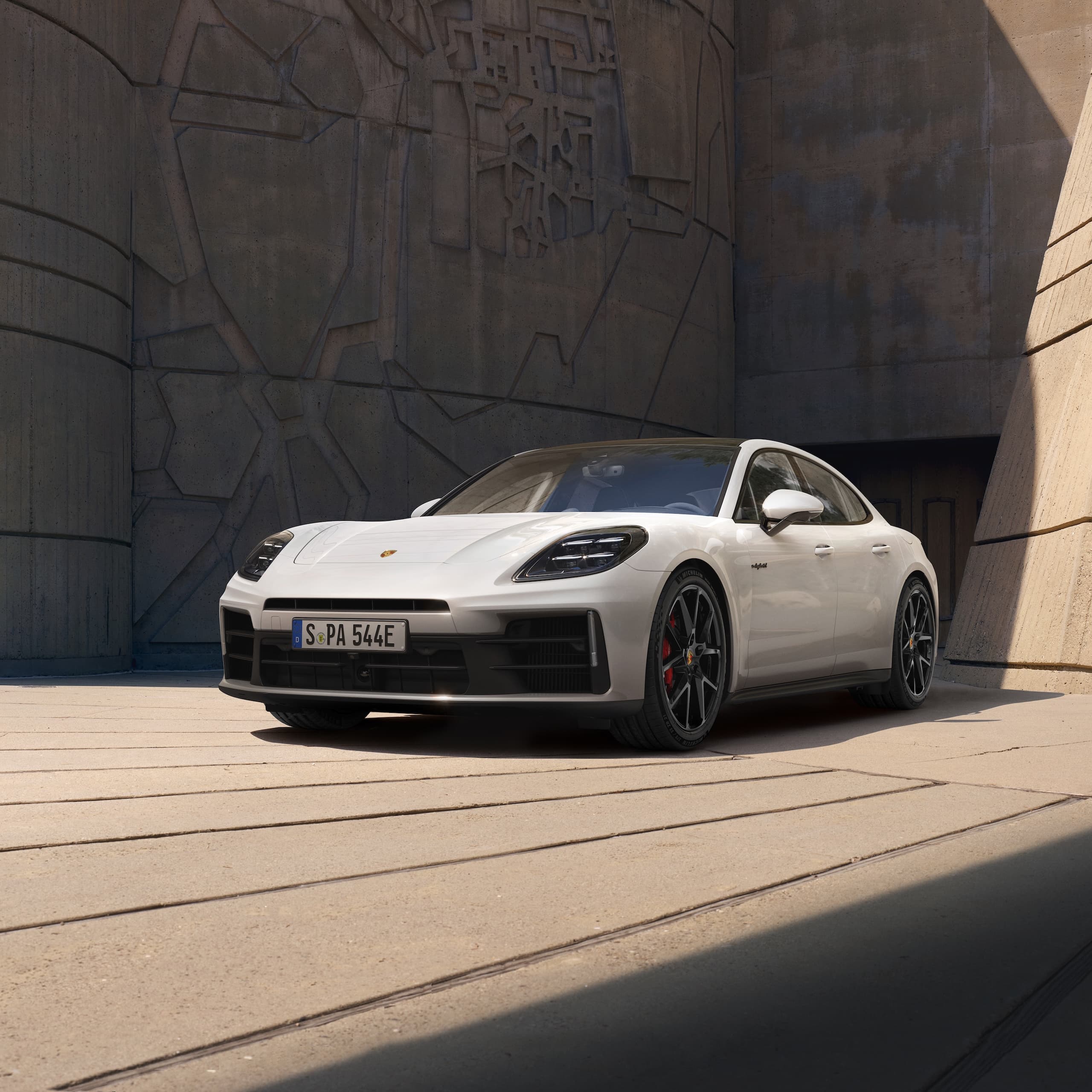 Ein Porsche Panamera parkte vor einem modernen Gebäude.